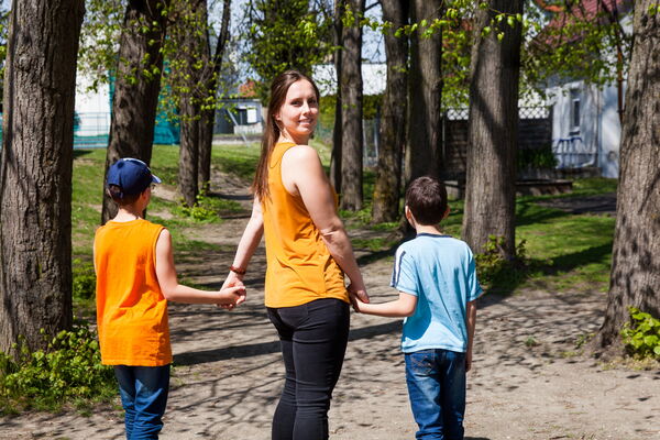 Junge Frau geht mit Kindern spazieren