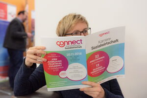 Auf dem Bild sieht man, wie eine Frau den Katalog liest