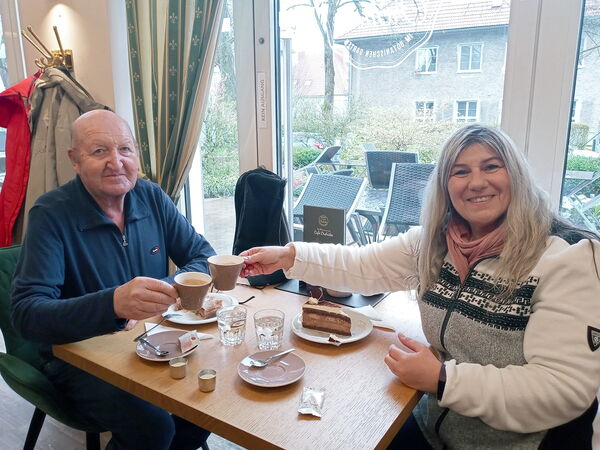 Ein älterer Herr und eine jüngere Frau trinken Kaffee