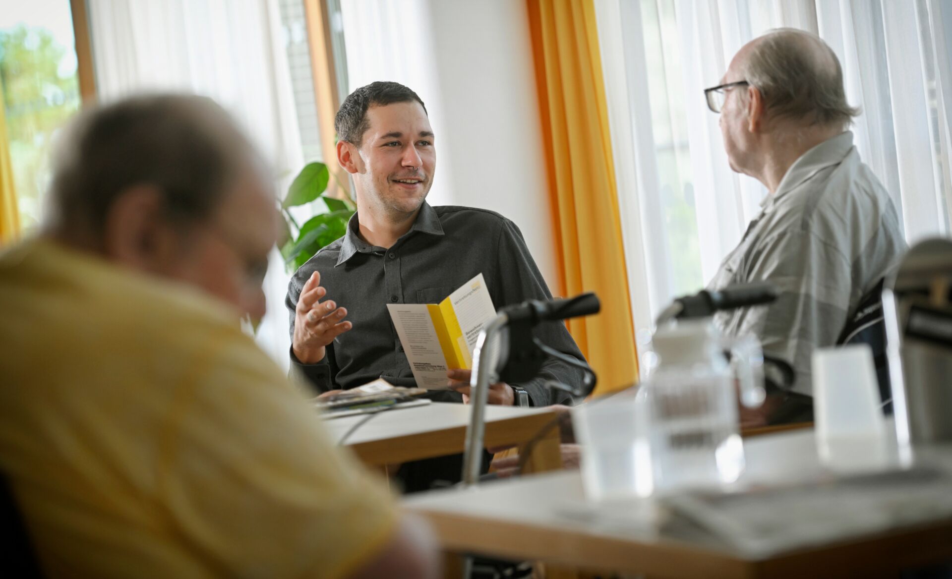 Menschen sitzen am Tisch beinander