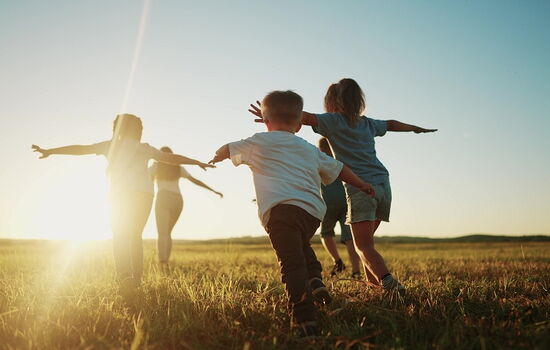 Kinder laufen über eine Wiese