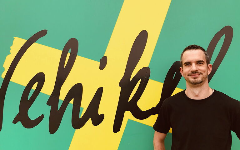 Im rechten Bildabschnitt sieht man Martin Beck vor dem Logo des Verein Vehikel