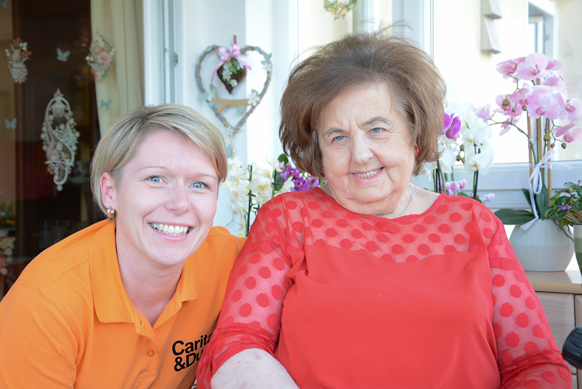 ein junge Frau und eine ältere lächeln in die Kamera